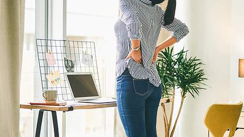 Eine Frau hält sich den Rücken - Foto: iStock/Charday Penn