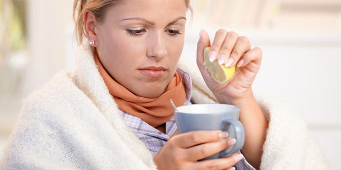 Eine Frau presst Zitrone in ihren Tee