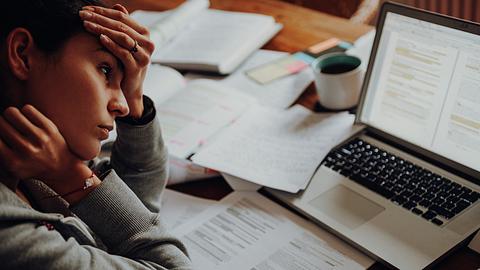 Erschöpfte Frau am Schreibtisch - Foto: iStock/Rocky89