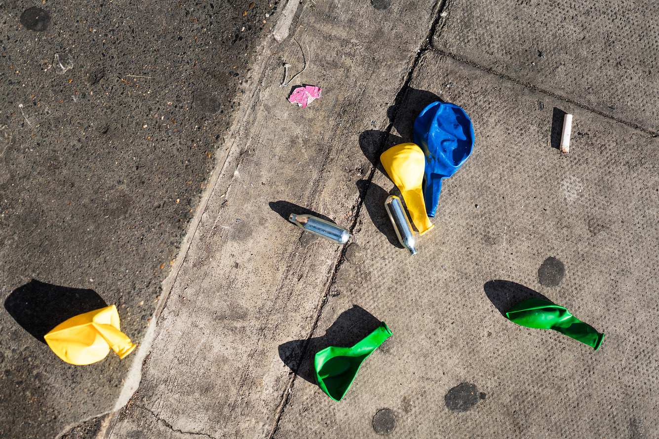 Lachgaskartuschen und Luftballons auf der Straße
