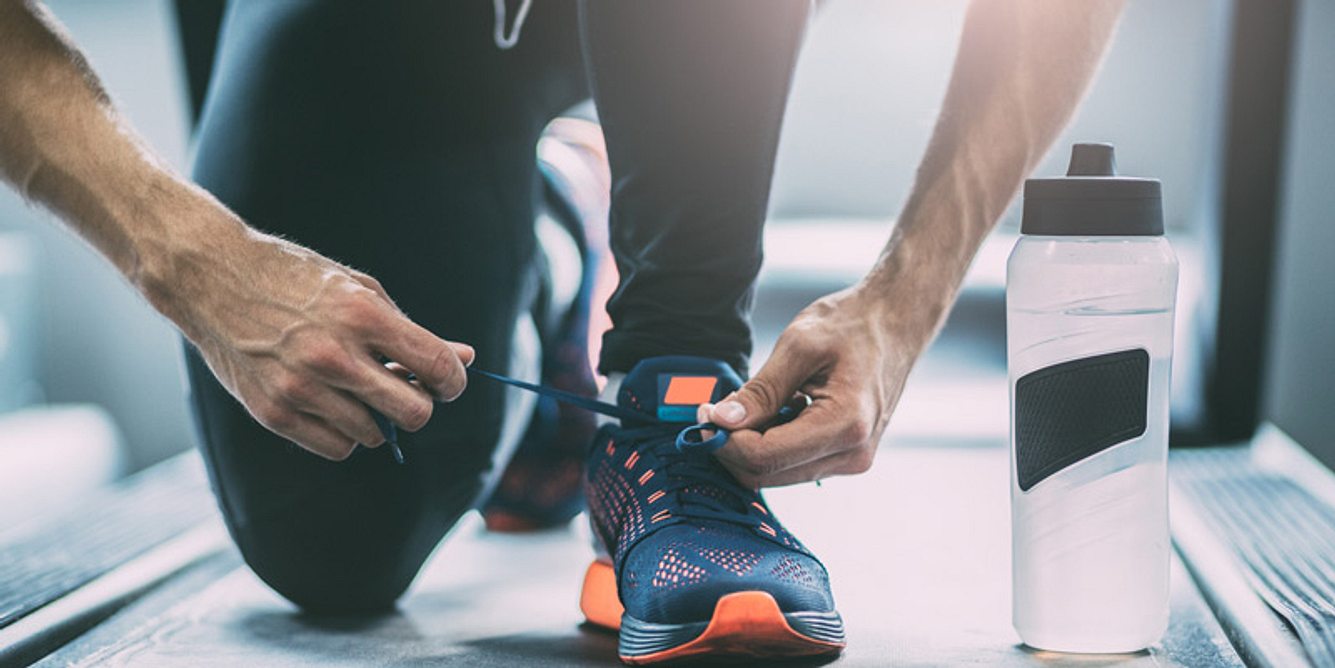 Mann bindet sich die Laufschuhe