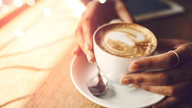 Eine Frau hält eine Kaffeetasse in den Händen - Foto: iStock/PeopleImages
