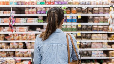 Frau steht vor Regalen im Supermarkt - Foto: iStock/asiseeit