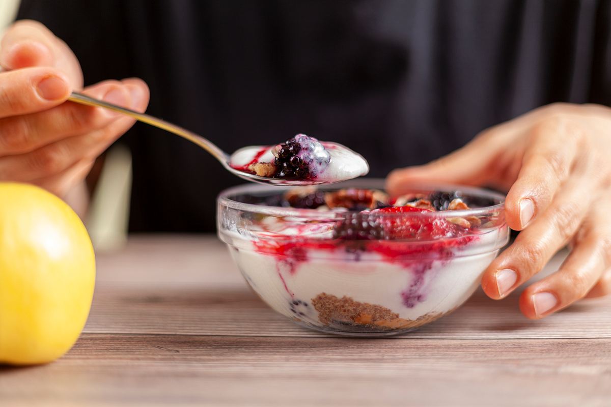 Frau isst Müsli mit Joghurt