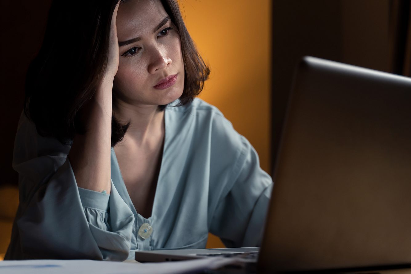 Eine Frau sitzt abends am Computer