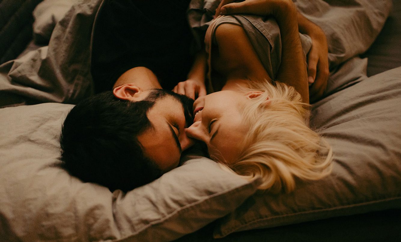 Ein Paar küsst sich im Bett