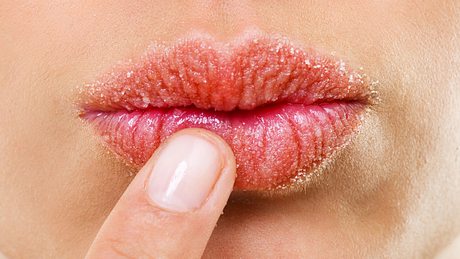 Ein Finger fässt sich an die Lippen, auf denen ein Peeling aufgetragen ist - Foto: istock_PeopleImages