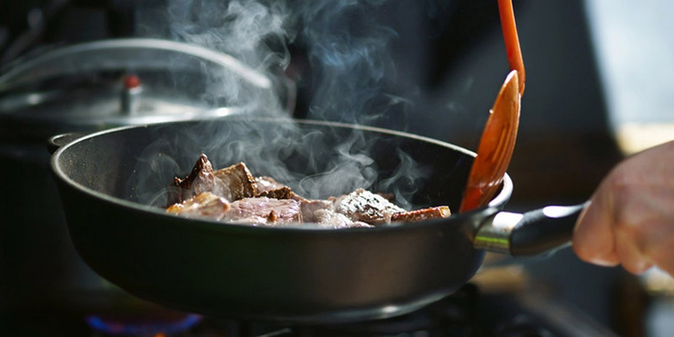 In einer Pfanne wird Fleisch angebraten