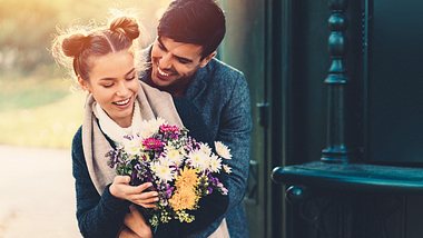Ein Mann schenkt seiner Freundin einen Blumenstrauß - Foto: iStock_martin-dm