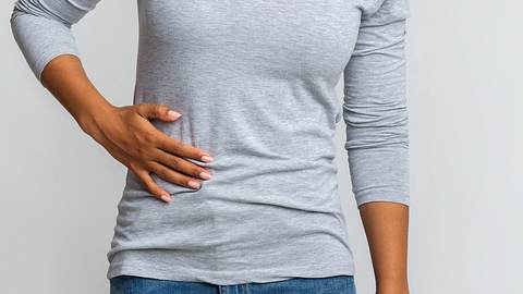 Eine Frau betastet ihren Bauch - Foto: iStock / Leber – Anatomiebegriff 