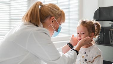 Eine Kinderärztin tastet bei einem Mädchen die Lymphknoten ab - Foto: iStock_Dobrila Vignjevic