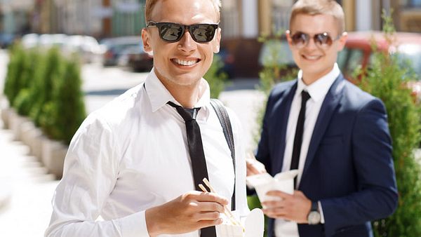 Zwei Männer essen im Gehen - Foto: Shutterstock