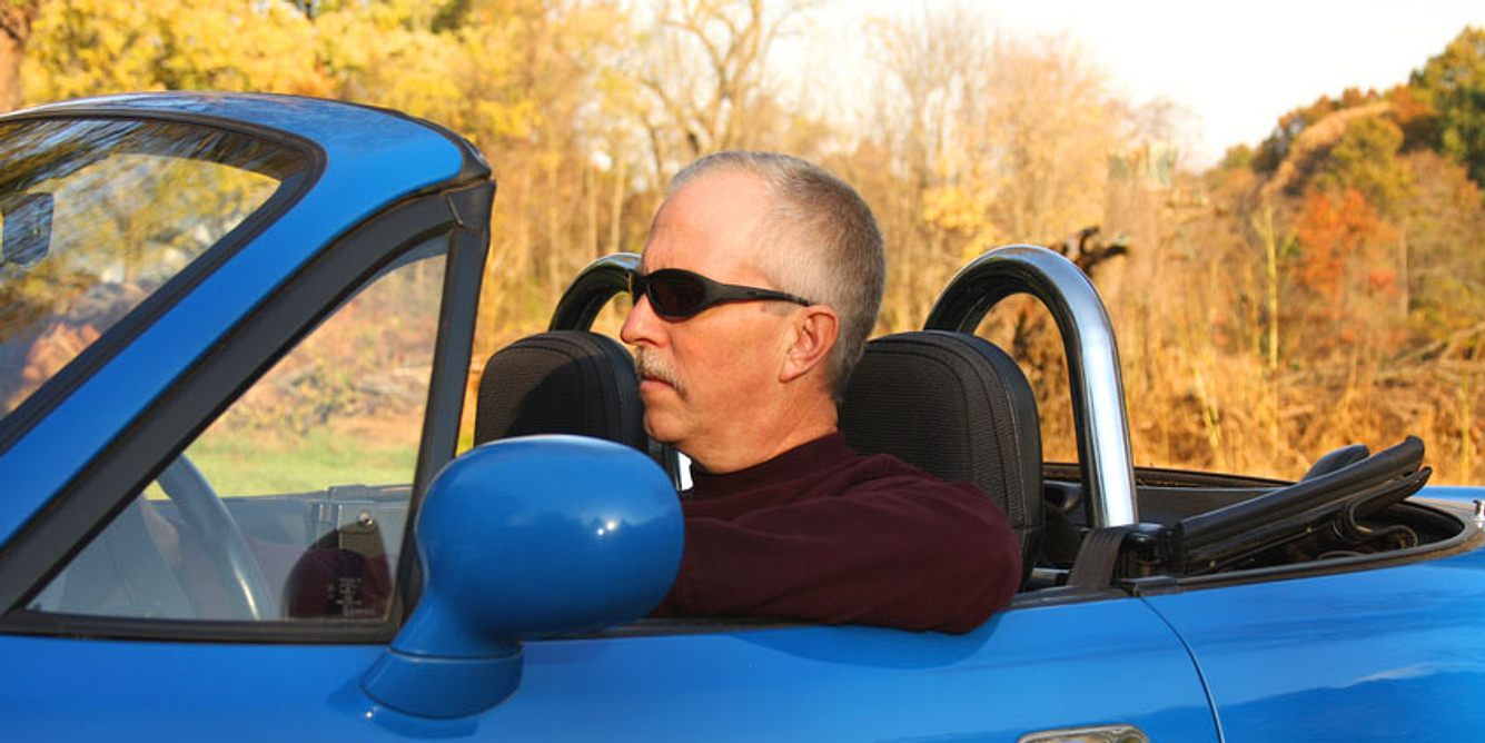 Männer in den Wechseljahren: Ein plötzlicher Stilwandel, z.B. ein neugekaufter Sportwagen samt Sonnenbrille können ein Zeichen dafür sein, dass ein Mann sich um seine Jugend und Potenz sorgt