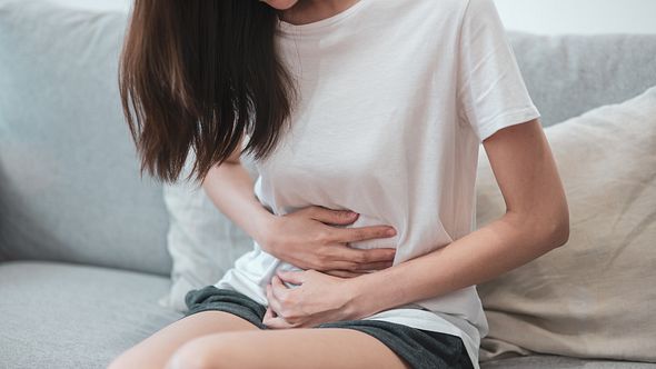 Frau hält sich den Bauch - Foto: iStock/Domepitipat