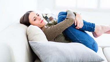 Traurige Frau auf der Couch - Foto: Alamy