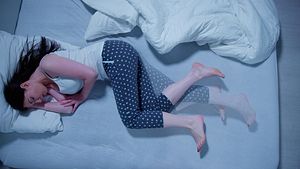 Frau liegt unruhig im Bett. - Foto: iStock / AndreyPopov