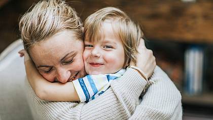 Eine Mutter umarmt ein kleines Kind und lacht - Foto: istock_skynesher