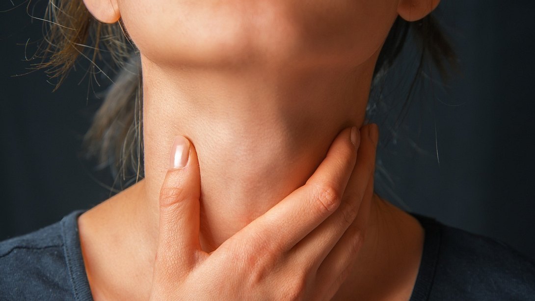 Eine Frau fasst sich an den schmerzenden Hals - Foto: iStock_Remains