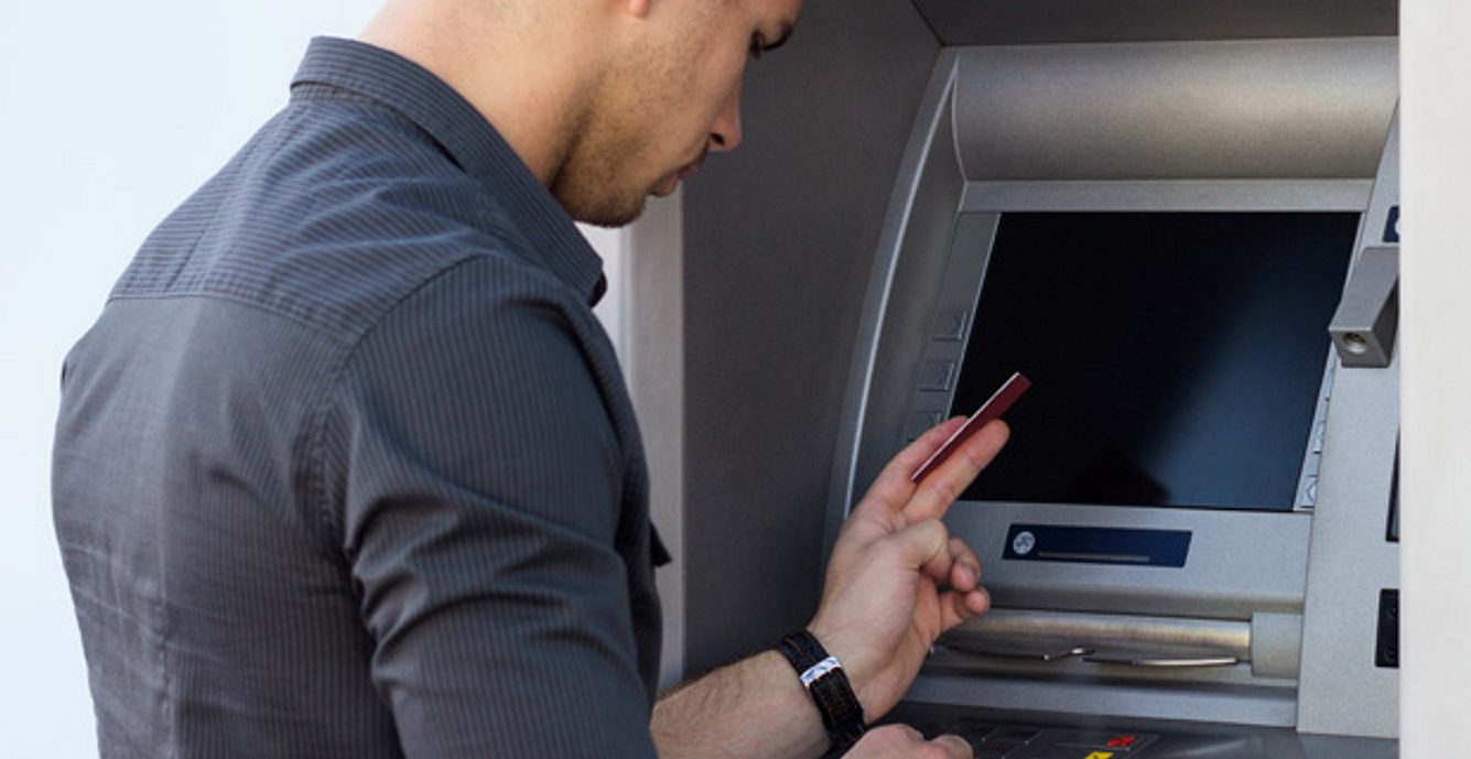 Ein Mann hebt Geld am Automaten ab