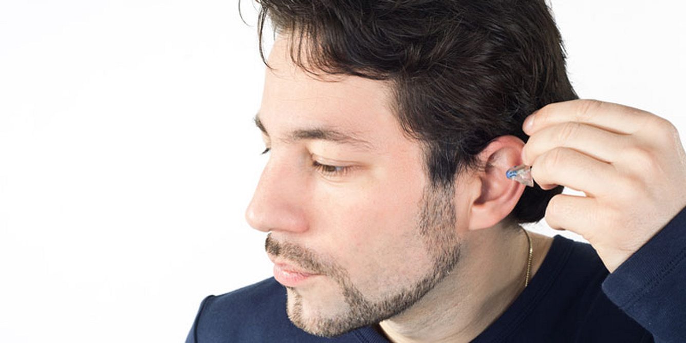Mann setzt Masker zur Tinnitus-Behandlung ein