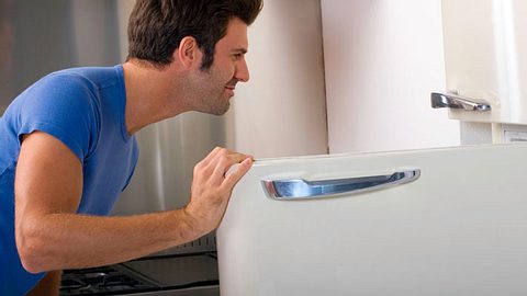 Ein Mann schaut in einen Kühlschrank - Foto: Shutterstock