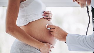 Ein Arzt untersucht eine schwangere Frau mit einem Stethoskop - Foto: istock_Vasyl Dolmatov