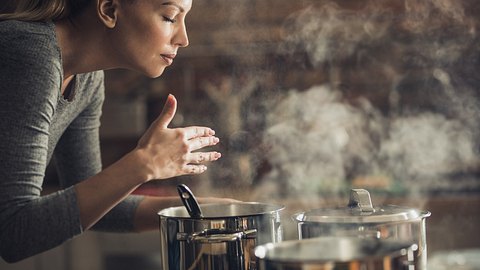 Frau hält Hände über Kochtopf - Foto: istock/skynesher