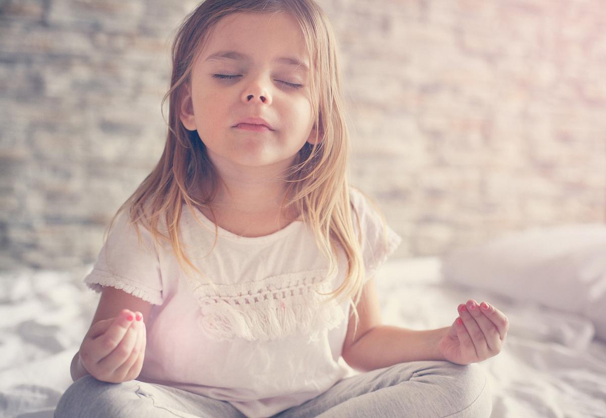 Mädchen meditiert im Bett