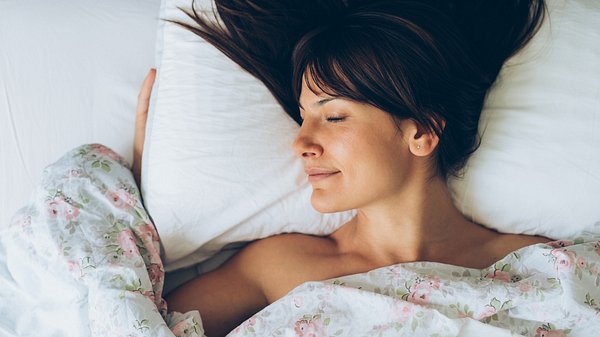 Frau liegt zufrieden im Bett - Foto: iStock/filadendron