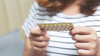 Eine Frau hält eine Pillenpackung in den Händen - Foto: iStock/RattankunThongbun