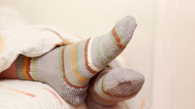 Eine Person schläft mit Socken - Foto: istock_Alex_Doubovitsky