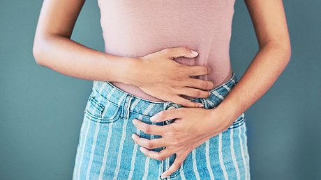 EIne Frau umfasst mit beiden Händen ihren unteren Bauch - Foto: istock_LaylaBird