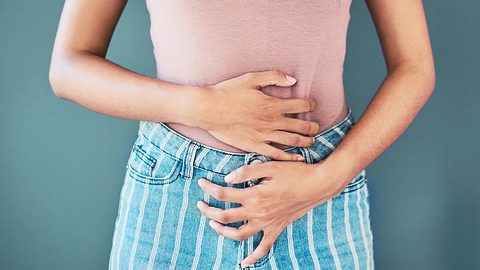 EIne Frau umfasst mit beiden Händen ihren unteren Bauch - Foto: istock_LaylaBird