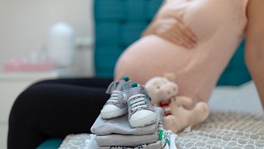Schwangere Frau sitzt auf dem Bett - Foto: mdphoto16/iStock