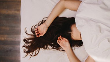 Frau mit Bettdecke über dem Gesicht - Foto: istock/jacoblund