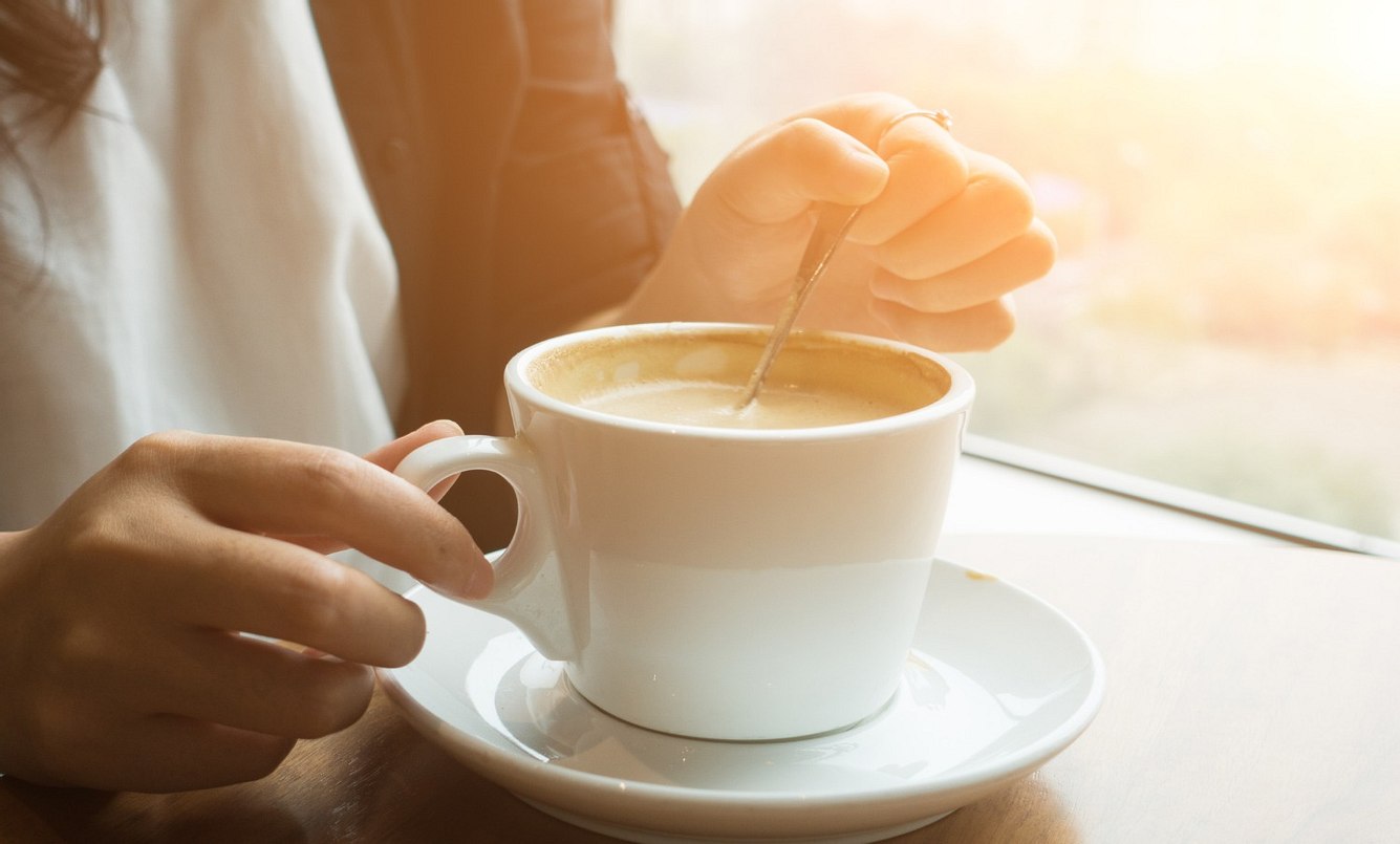 Frau rührt in Tasse mit Mushroom Coffee