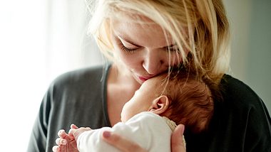 Mutter küsst Baby - Foto: iStock/Mikolette
