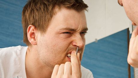 Mann zupft Nasenhaare aus - Foto: Alamy
