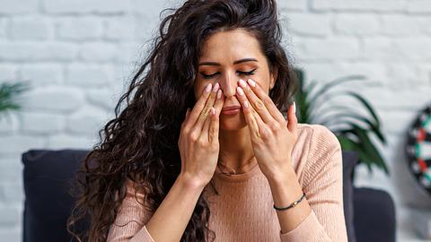 Frau fasst sich an die Nebenhöhlen - Foto: iStock/RealPeopleGroup