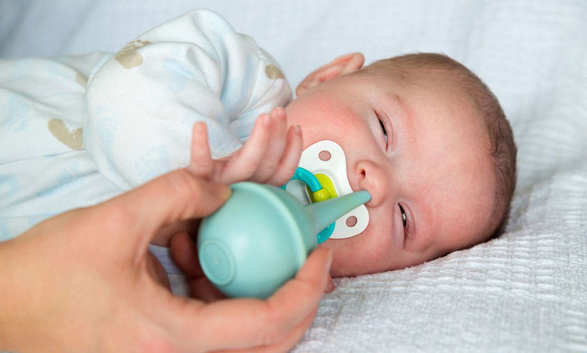 Die Nase eines kranken Babys wird mit einem Nasensauger gereinigt