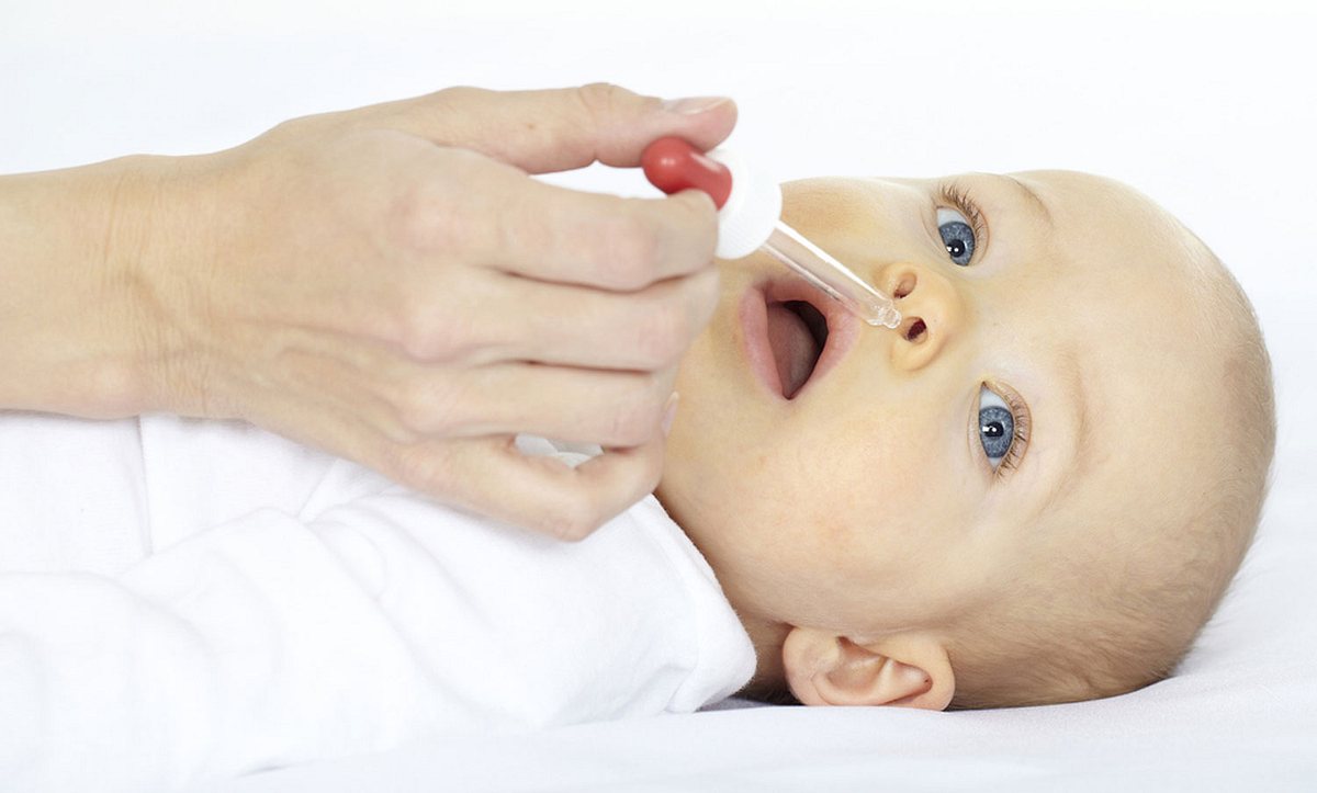 Ein Baby bekommt Nasentropfen