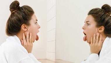 Frau untersucht ihre Zunge - Foto: istock/privetik
