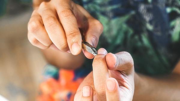 Eine Frau knipst Nagelhaut am Finger ab - Foto: istock_Malik Evren