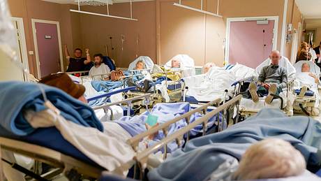 Viele Menschen in Krankenhausbetten auf einem Flur - Foto: IMAGO / Hans Lucas