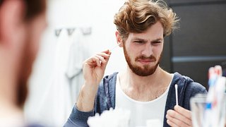 Mann mit Wattestäbchen im Ohr - Foto: shironosov/iStock