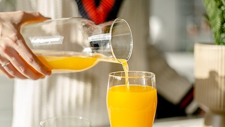 Eine Frau füllt Orangensaft in ein Glas - Foto: iStock_Jokic