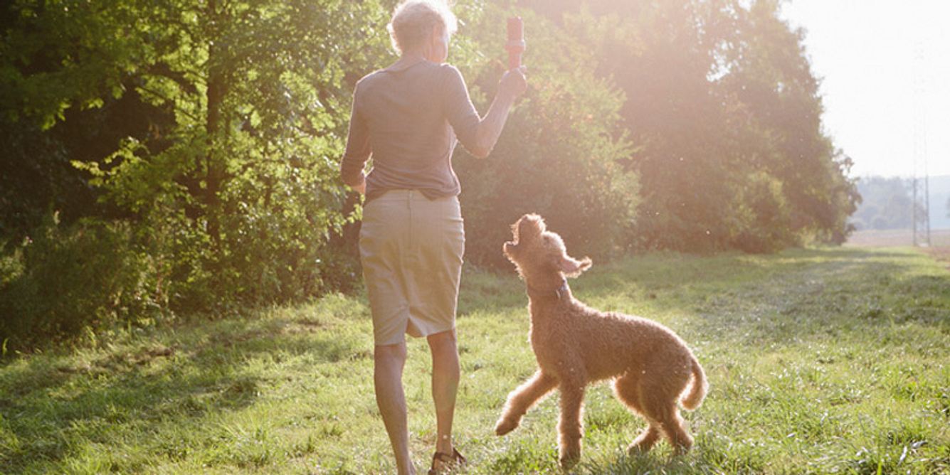 Eine Frau geht mit ihrem Hund spazieren