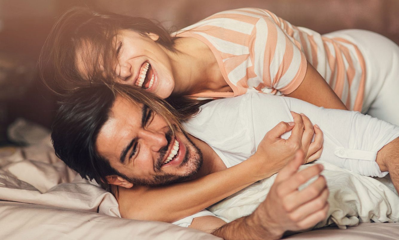 Verliebtes Pärchen lachend im Bett