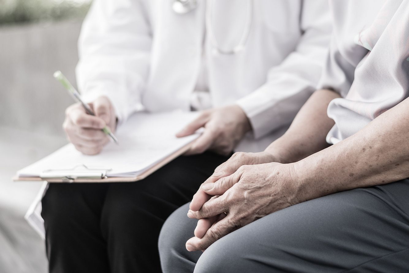 Arzt füllt Fragebogen mit Patientin aus