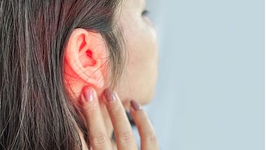 Eine Frau hält ihre Hand ans Ohr, das rot umkreist ist - Foto: iStock/:Doucefleur